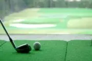golf mat in and club in front of a golf simulator