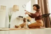 A BIPOC woman playing with a white small dog in her home Gen Z and millennial homeowners