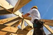 Single-family housing starts higher in April - man constructing wooden frame of home