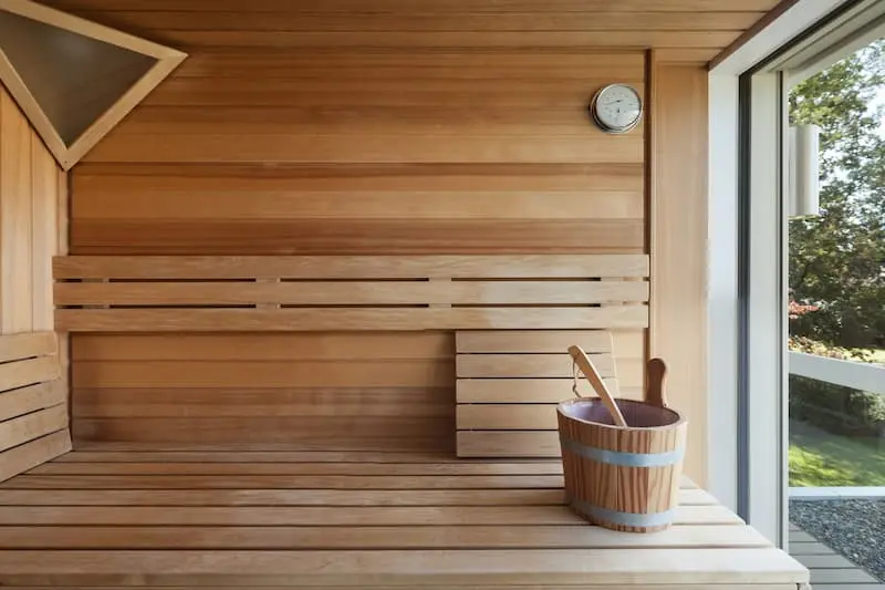 a sauna with wooden bucket and window to outside.